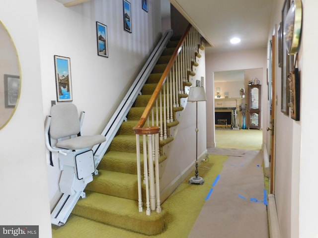 staircase featuring a fireplace, carpet, baseboards, and recessed lighting