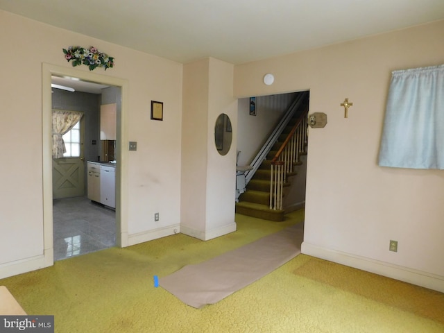 interior space featuring baseboards, carpet floors, and stairs