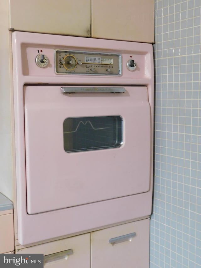 details with washer / dryer and white cabinets