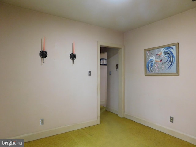 unfurnished room featuring baseboards and light colored carpet