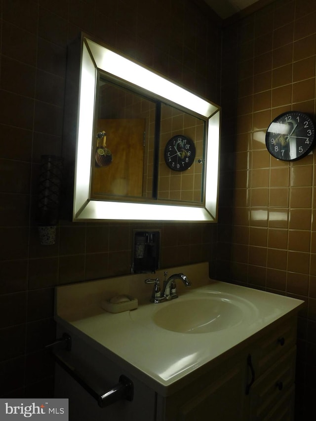 bathroom with vanity and tile walls