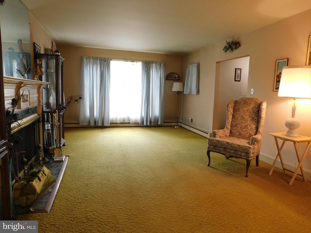 living area featuring a baseboard radiator, a fireplace with raised hearth, and carpet flooring