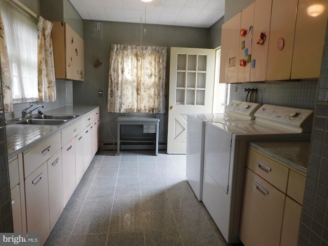 clothes washing area with washing machine and clothes dryer, laundry area, and a sink