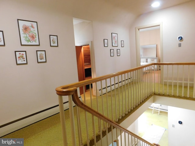 hallway with a baseboard radiator, carpet, and an upstairs landing