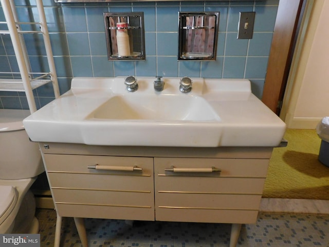 half bath featuring tile walls, vanity, and toilet