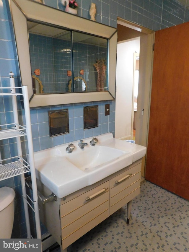 bathroom featuring tile walls, vanity, backsplash, and toilet