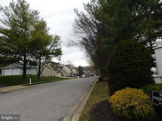 view of street featuring curbs, sidewalks, and a residential view