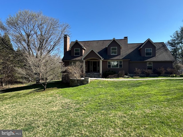cape cod-style house featuring a chimney and a front lawn