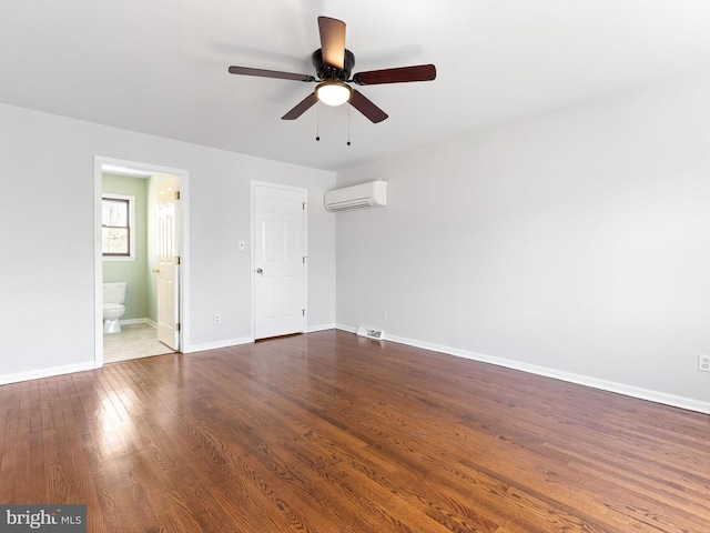 666 Clifton Dr, Bear, DE 19701 - unfurnished bedroom with dark wood-style floors, visible vents, an AC wall unit, baseboards, and ensuite bathroom