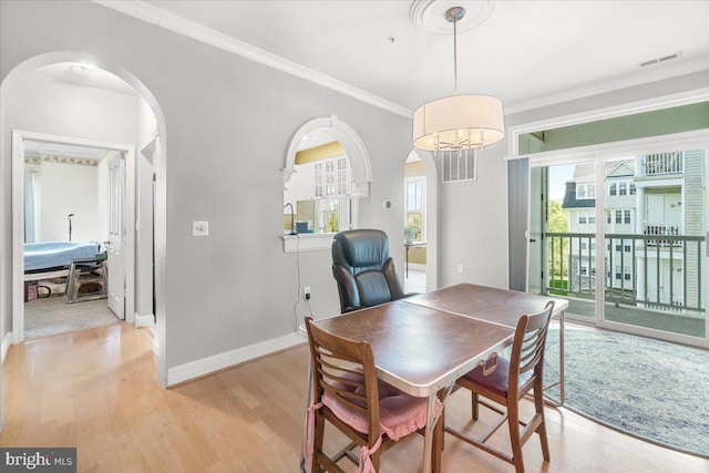 dining area featuring arched walkways, visible vents, and a healthy amount of sunlight