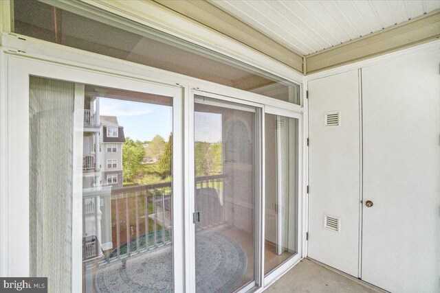 view of exterior entry with a balcony and visible vents