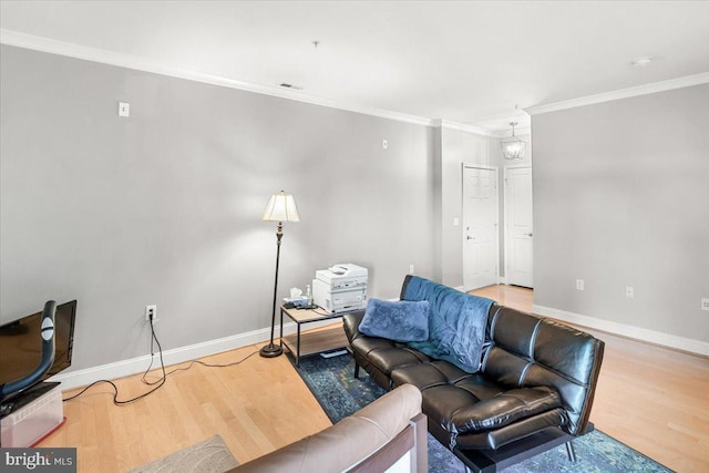 living room with baseboards, crown molding, wood finished floors, and visible vents