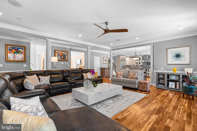 living area featuring ornamental molding, wood finished floors, ceiling fan, recessed lighting, and ornate columns