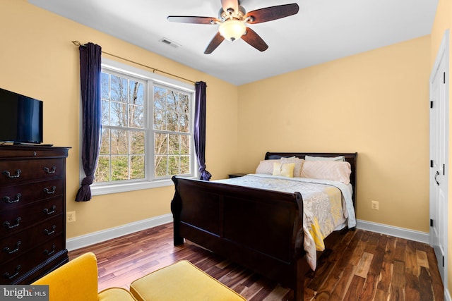 bedroom with baseboards, visible vents, wood finished floors, and a ceiling fan