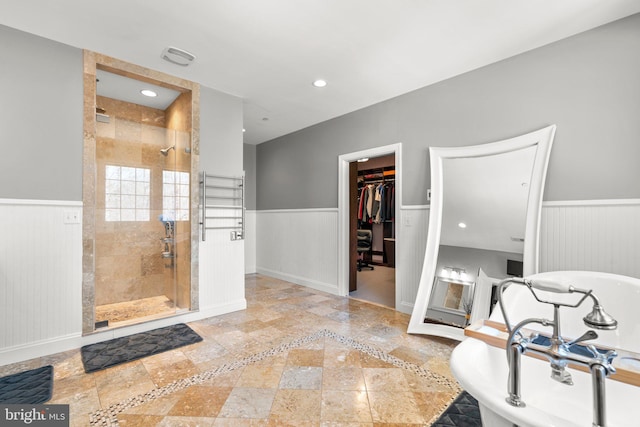 bathroom featuring wainscoting and a shower stall