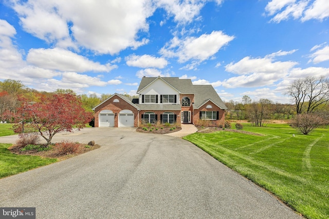 traditional-style house featuring aphalt driveway, a garage, a front lawn, and brick siding