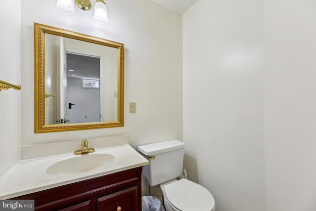 half bath featuring vanity and toilet