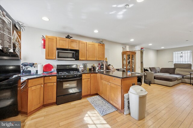 1843 N 18th St, Philadelphia, PA 19121 - kitchen with stainless steel microwave, a sink, light wood-style floors, black gas range oven, and a peninsula