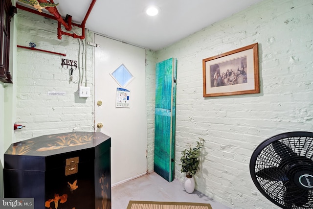 interior space featuring brick wall and finished concrete floors
