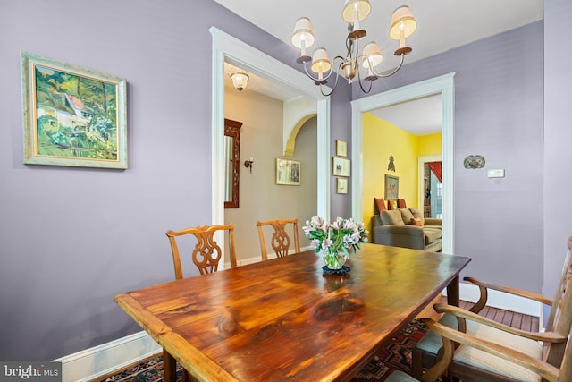 dining room with baseboards and a notable chandelier