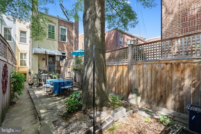 back of property featuring brick siding, a patio area, fence, and outdoor dining space