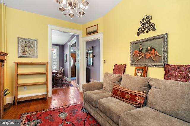 living room with baseboards, an inviting chandelier, and dark wood finished floors