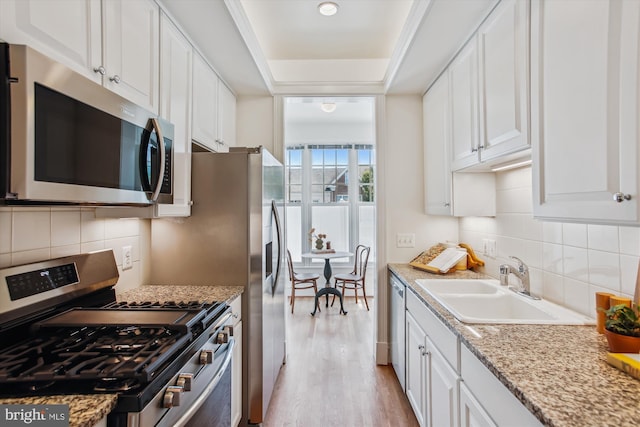 979 Powhatan St, Alexandria, VA 22314 - kitchen featuring white cabinetry, appliances with stainless steel finishes, a sink, and light wood-style floors