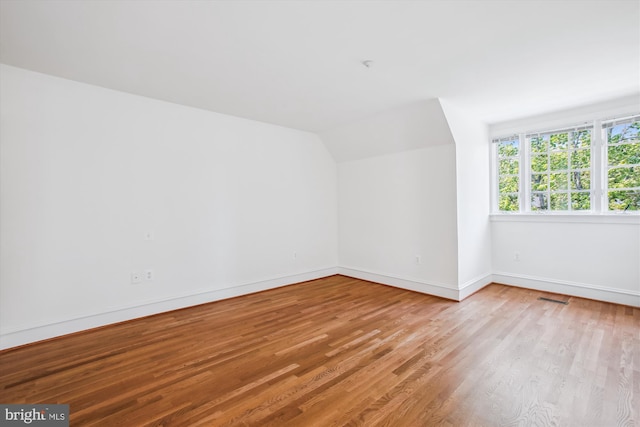 979 Powhatan St, Alexandria, VA 22314 - additional living space with visible vents, baseboards, wood finished floors, and vaulted ceiling