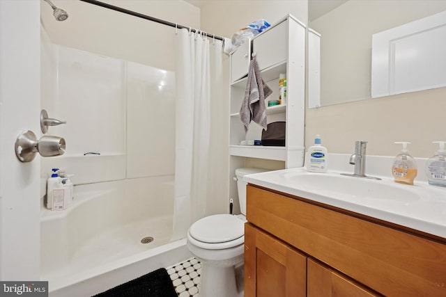 bathroom with toilet, vanity, and a stall shower