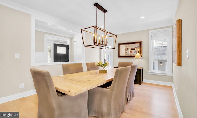 dining space featuring baseboards, light wood-type flooring, a chandelier, crown molding, and recessed lighting