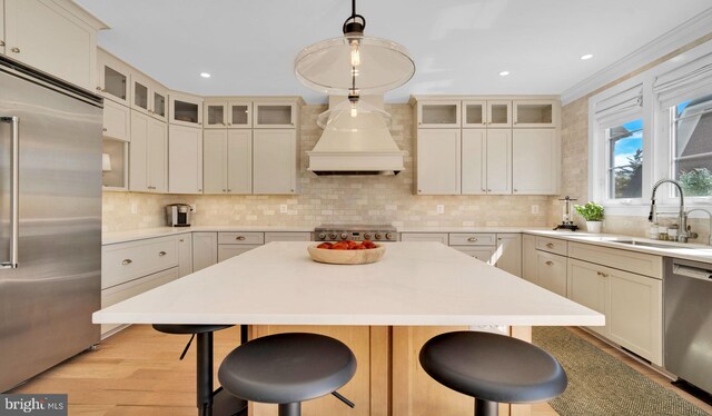 kitchen featuring stainless steel appliances, a sink, a breakfast bar area, backsplash, and recessed lighting