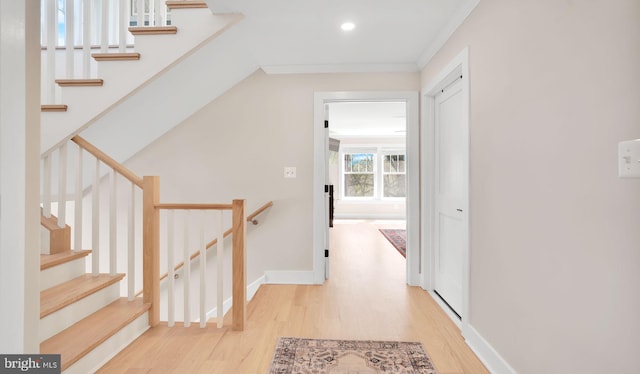 hallway featuring light wood finished floors, baseboards, and recessed lighting
