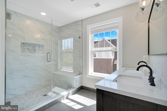 full bath featuring a marble finish shower, tile patterned flooring, double vanity, recessed lighting, and baseboards