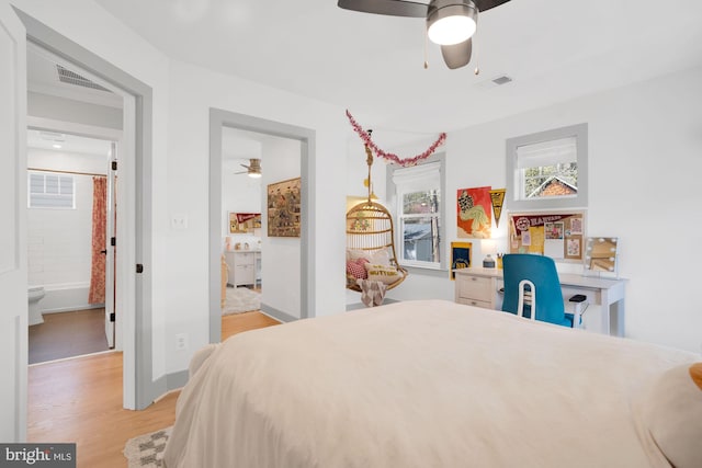 bedroom with multiple windows, wood finished floors, baseboards, and ceiling fan
