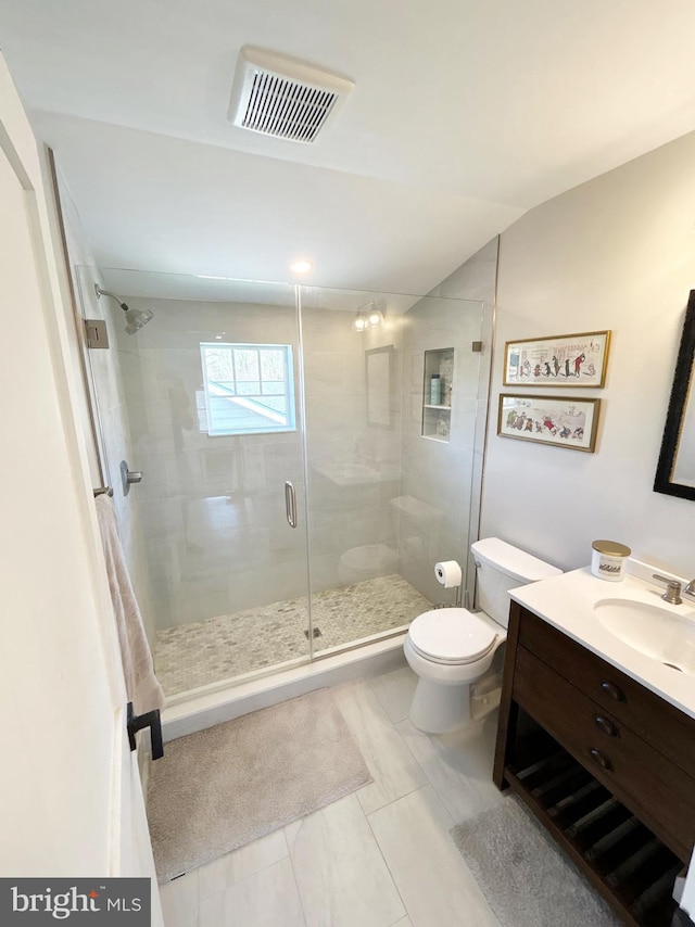 bathroom featuring toilet, a stall shower, and vanity