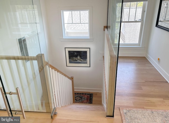 staircase with wood finished floors and baseboards
