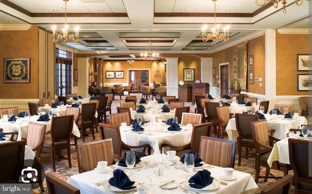 interior space with crown molding, a wainscoted wall, coffered ceiling, and a chandelier