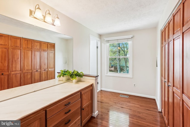 15690 Buck Ln, Dumfries, VA 22025 - bathroom with a textured ceiling, wood finished floors, visible vents, and baseboards