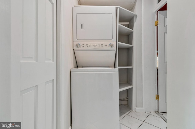 washroom featuring stacked washing maching and dryer, tile patterned floors, and laundry area
