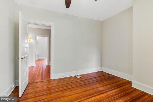 empty room featuring baseboards, a ceiling fan, and hardwood / wood-style flooring