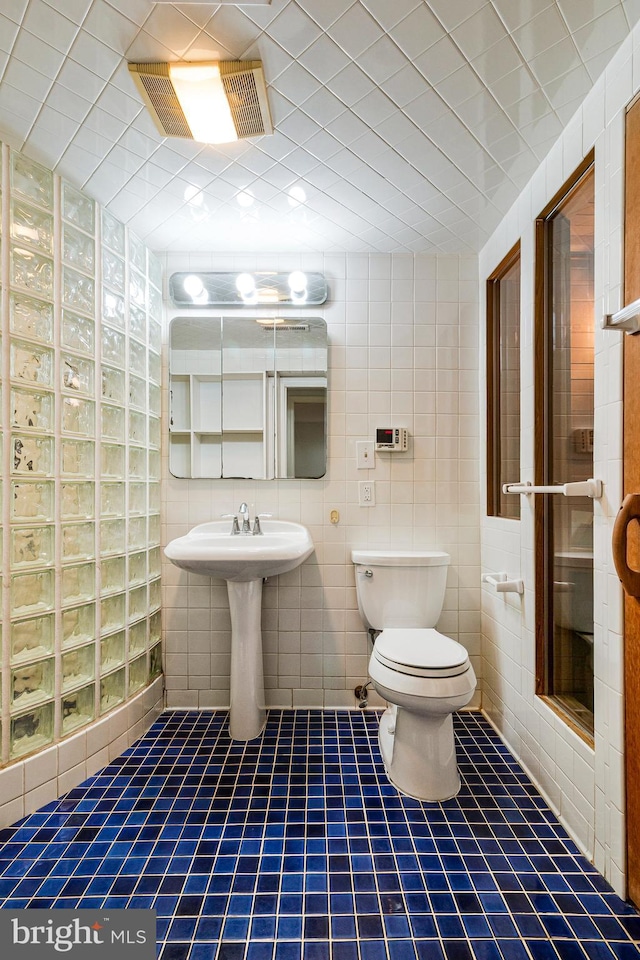 full bath featuring tile patterned flooring, visible vents, toilet, and a shower stall