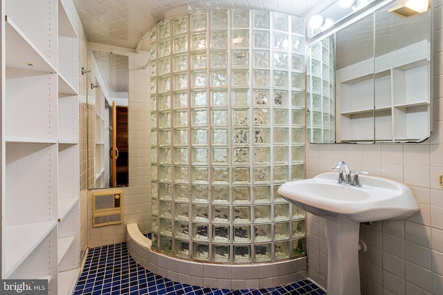 bathroom with tile walls, a tile shower, and tile patterned flooring