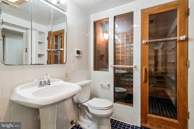 full bath featuring visible vents, toilet, tile walls, tile patterned floors, and a shower stall