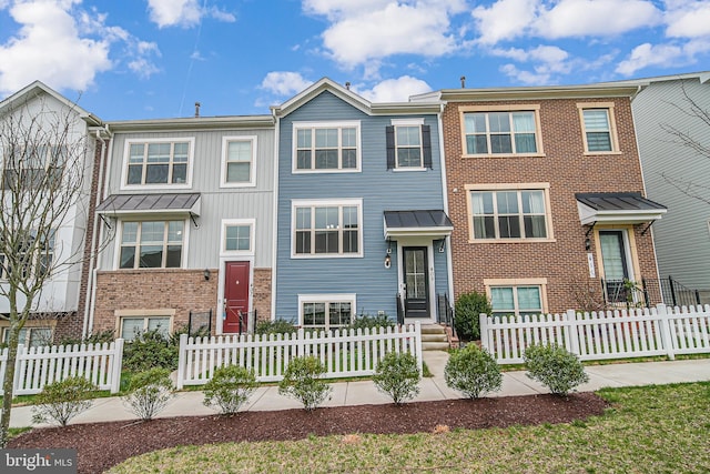 townhome / multi-family property featuring brick siding and a fenced front yard