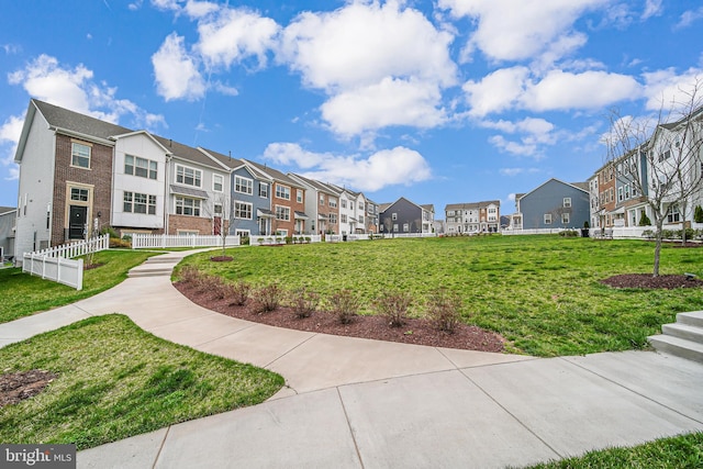 surrounding community with a residential view, a yard, and fence