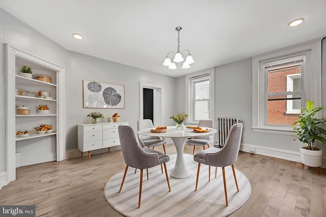 dining area featuring recessed lighting, light wood-style flooring, radiator, baseboards, and a notable chandelier