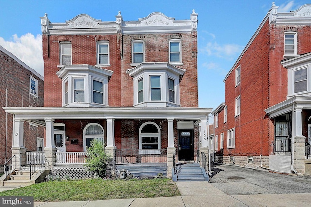 view of front facade with covered porch and brick siding