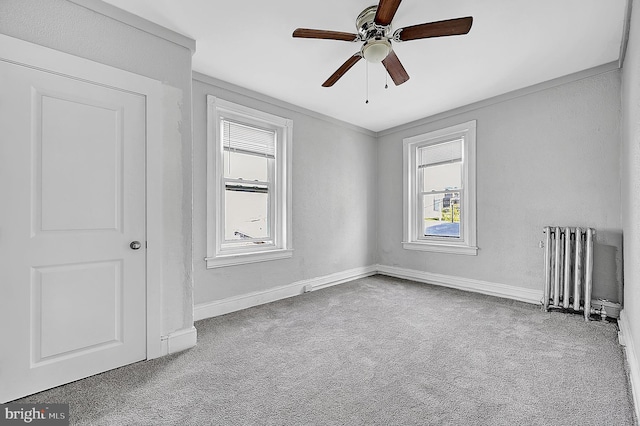 carpeted spare room with a ceiling fan, radiator heating unit, and baseboards