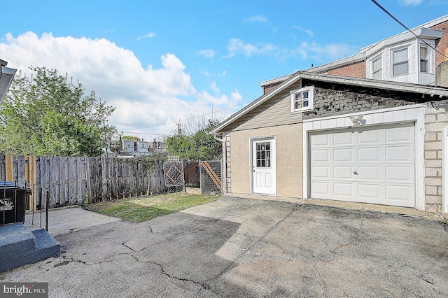 garage with fence and driveway