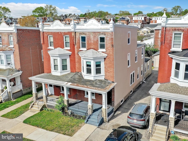 view of front facade featuring covered porch, brick siding, and a residential view